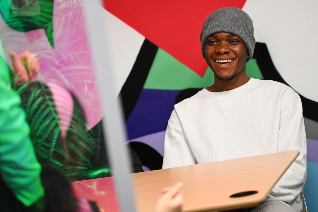 Student laughing in the podcast studio