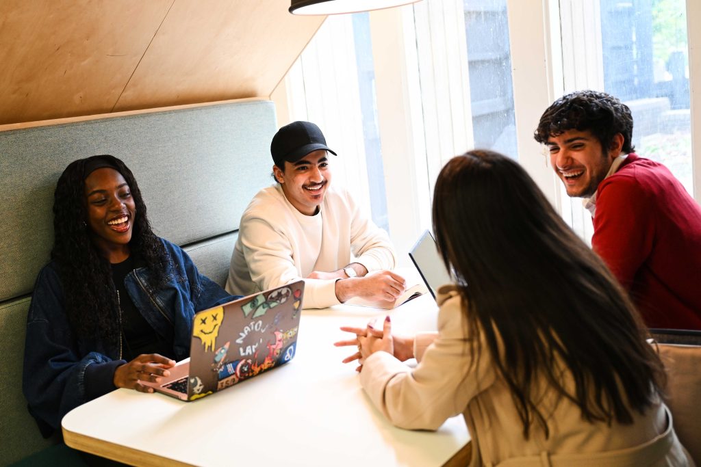 Students laughing sat around a table