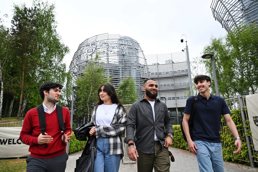 Group of students walking outside of the business building on campus